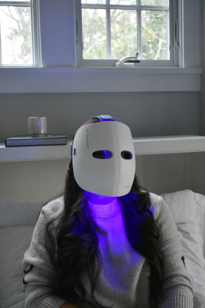 Allure contributing commerce writer Christa Joanna Lee using the TheraFace Mask Glo in blue light mode